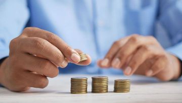 Alkandoradun gizon baten eskuak dorreak txanponekin egiten